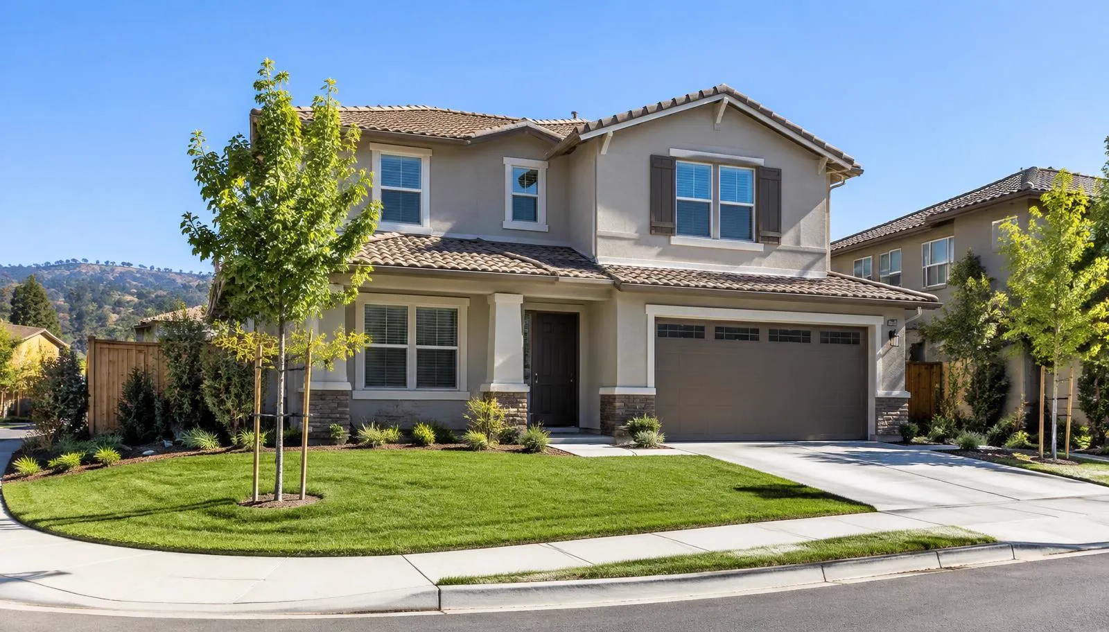 Two-story suburban home with a brown tile roof and a green lawn.